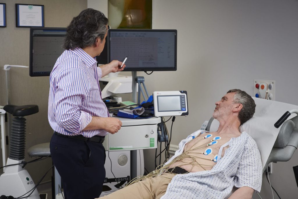 Doctor giving a patient who is experiencing chest pain and shortness of breath an ECG test at a Winnipeg clinic